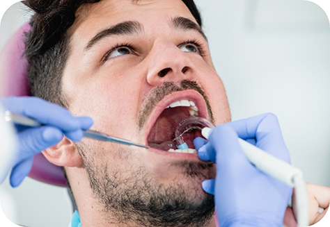 Man with facial hair having teeth examined