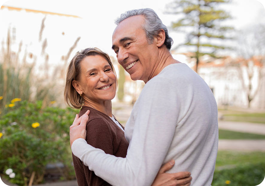 Senior man and woman hugging outside