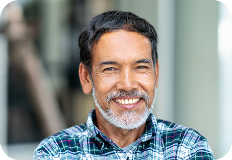 Man with beard smiling outside