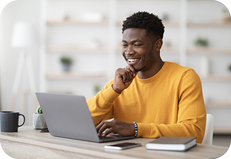 Man in yellow shirt looking at laptop