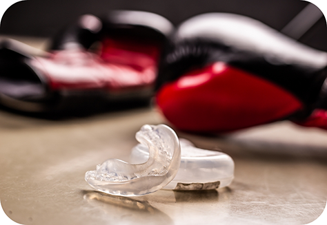 Athletic mouthguard on desk with boxing gloves