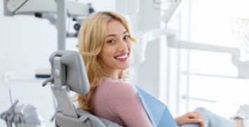 Blonde woman in dental chair smiling