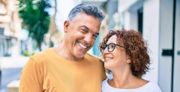 Man and woman walking down street and smiling