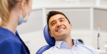 Male dental patient smiling up at dentist