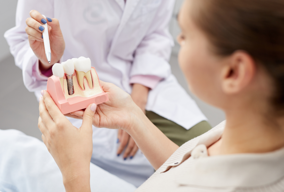 Dentist showing patient dental implant model